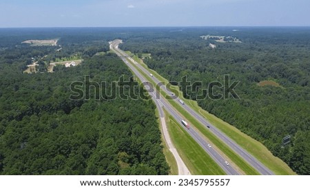 Lush green Loblolly pine tree Pinus taeda in forestry site along highway interstate 10 (I-10) near entrance to rest area in Greenwood, Louisianan, USA. Aerial modern freeway rest stop transportation