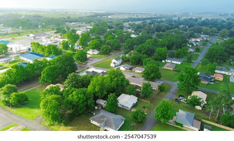 Lush green residential neighborhood near historic downtown red brick buildings in Checotah, McIntosh County, Oklahoma, Midwest small town USA landscape in early foggy morning light, aerial view. USA - Powered by Shutterstock