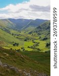 A lush green valley with a patchwork of rolling hills and lush grassy fields.