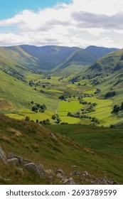 A lush green valley with a patchwork of rolling hills and lush grassy fields.