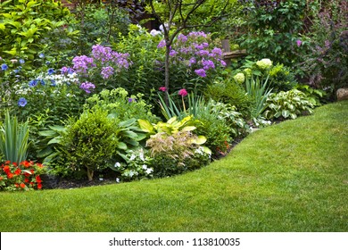 Lush Landscaped Garden With Flowerbed And Colorful Plants