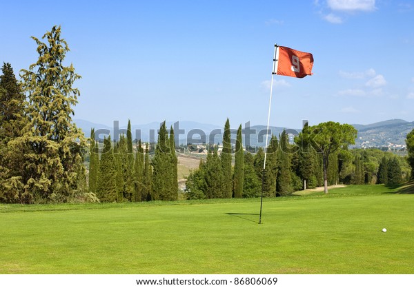 The lush, manicured green at the ninth\
hole of a luxurious golf course in Tuscany,\
Italy