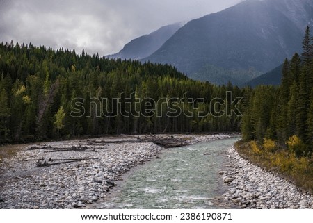 Lussier River in Whiteswan Provincial Park, Kootenay Rockies, British Columbia, Canada. View of an autumn forest, mountains, and turquoise water of the river