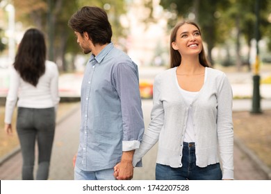 Lustful Cheating Boyfriend Looking At Other Woman Walking With Girlfriend In Park Outdoors. Selective Focus