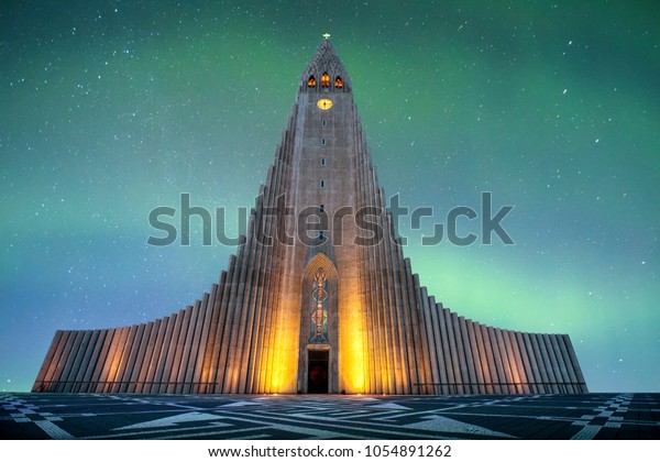 ハルグリムスカーキャはレイキャビクのルテラン アイスランド教会 教会です これはアイスランド最大の教会で アイスランドで最も高い建物です 背景にはカラフルなオーロラのボレアリスがあります の写真素材 今すぐ編集