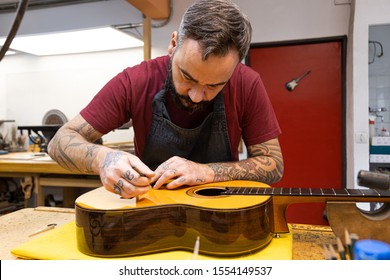 luthier craftsman adjusting a classic guitar