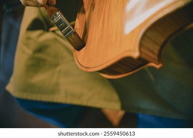 Luthier is meticulously applying varnish with a brush on the wooden surface of a handcrafted violin, showcasing the dedication and precision involved in the art of violin making - Powered by Shutterstock