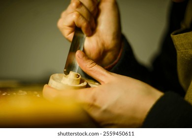 Luthier meticulously carves a piece of wood, using a sharp chisel, demonstrating the precision and craftsmanship involved in creating musical instruments - Powered by Shutterstock