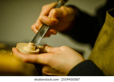 Luthier meticulously shaping a piece of wood with a chisel, creating an intricate component for a violin, demonstrating the craftsmanship and precision involved in musical instrument making - Powered by Shutterstock