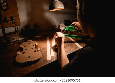 Luthier on his back measuring his tools to make a violin. - Powered by Shutterstock