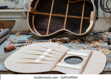 Luthier workbench with tools and an acoustic guitar under construction