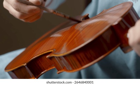 Luthier working diligently in a workshop, carefully assembling violin parts with specialized tools and techniques, showcasing craftsmanship and dedication to the art of instrument making