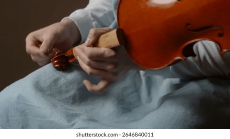 Luthier working diligently in a workshop, carefully assembling violin parts with specialized tools and techniques, showcasing craftsmanship and dedication to the art of instrument making