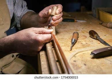 Luthier working on making a violin bow in his workshop - Powered by Shutterstock