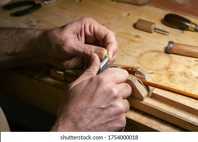 Luthier working on making a violin bow in his workshop - Powered by Shutterstock