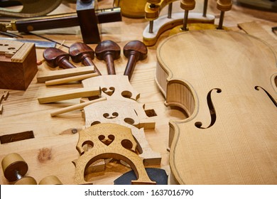 Luthier workshop with violin wooden parts and tools. Traditional craftmanship. 