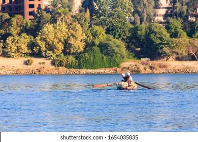 Luxor, Egypt - December 11, 2018: Two Egyptian Men Fishing With Fishing Nets In Old Rowing Boat On Nile River