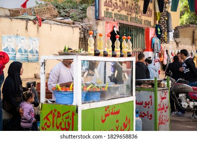 LUXOR, EGYPT - OCTOBER 7, 2020: Mother And Child Wait For Falafel On Streets Of Luxor, Egypt