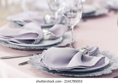 Luxurious Banquet Table Setting With Purple Napkins.