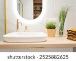 Luxurious bathroom with ceramic bathroom sink with golden faucet on counter and modern mirror. Contemporary interior in new apartment and hotel.	