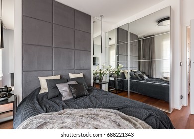 Luxurious Bedroom With Mirrored Wardrobe, Double Bed And Upholstered Wall