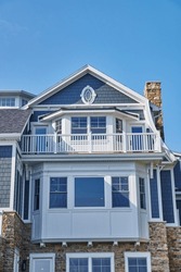 Luxurious Coastal House With Blue Shingles And Stone Foundation