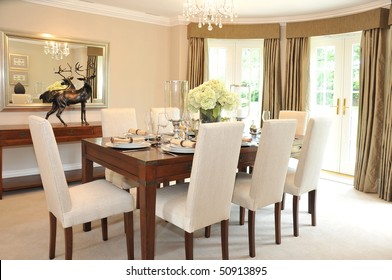 A Luxurious Dining Room With Table And Chairs Set For A Meal