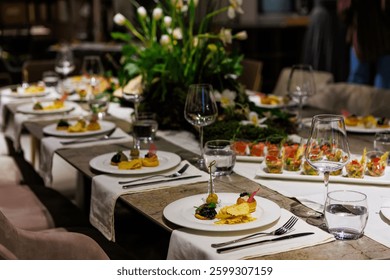 Luxurious dining table setup featuring gourmet appetizers, elegant glassware, floral centerpiece, and sophisticated decor, ideal for upscale events, weddings, banquets, and exclusive dinner parties.