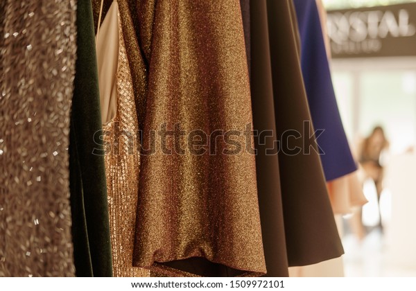Luxurious evening night out sparkling dresses\
hanging on the rack. High fashion, haute couture, designer concept.\
Closeup details