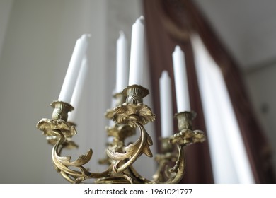 A Luxurious Gold Candle Holder With White Candles.