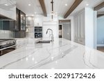 Luxurious high end kitchen with stainless appliances marble and glass tile