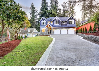 Luxurious Home Exterior With Blue Vinyl Siding And White Trim. Long Concrete Driveway Lead To Three Attached Garage Spaces. Beautiful Curb Appeal. Northwest, USA