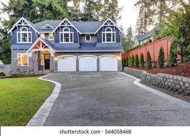 Luxurious Home Exterior With Blue Vinyl Siding And White Trim. Long Concrete Driveway Lead To Three Attached Garage Spaces. Beautiful Curb Appeal. Northwest, USA