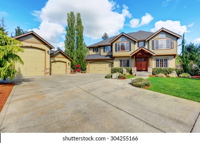 Luxurious Home With Well Kept Lawn, And Green Exterior Paint.