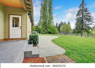 Luxurious Home With Well Kept Lawn, And Green Exterior Paint.