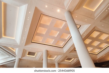 Luxurious hotel lobby with marble stairs, tall pillars, decorative palm trees, and artistic mural creating an elegant atmosphere. - Powered by Shutterstock