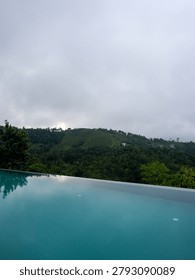  Luxurious infinity pool overlooking the dense tropical green mountains and valley of Vagamon hill station, Kerala, India.