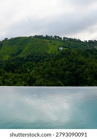  Luxurious infinity pool overlooking the dense tropical green mountains and valley of Vagamon hill station, Kerala, India.