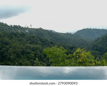  Luxurious infinity pool overlooking the dense tropical green mountains and valley of Vagamon hill station, Kerala, India.