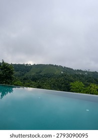  Luxurious infinity pool overlooking the dense tropical green mountains and valley of Vagamon hill station, Kerala, India.