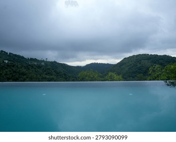  Luxurious infinity pool overlooking the dense tropical green mountains and valley of Vagamon hill station, Kerala, India.
