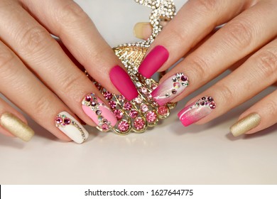 A luxurious manicure and pink matte finish for nails   gradient from white and gold to pink nail Polish Nail art and various shaped rhinestones   colors 