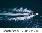 Luxurious  motor boat rushes through the waves of the blue Sea. Boat fast moving aerial view. Luxurious boat fast movement on dark water.