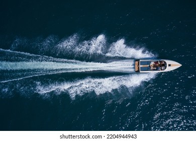 Luxurious  motor boat rushes through the waves of the blue Sea. Boat fast moving aerial view. Luxurious boat fast movement on dark water. - Powered by Shutterstock