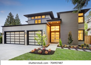 Luxurious New Construction Home In Bellevue, WA. Modern Style Home Boasts Two Car Garage Spaces With Glass Folding Doors Illuminated By Scones. Northwest, USA