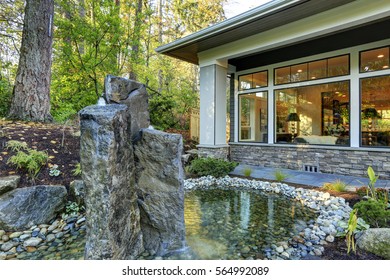 Luxurious New Construction Home Exterior With Perfect Landscape Design: Nice Garden Pond With Stone Fountains. Northwest, USA
