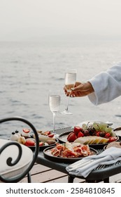 A luxurious oceanfront dining experience featuring a scenic view of the sea, elegant table setup, and gourmet cuisine. Perfect setting for a relaxing and sophisticated meal by the water in Greece