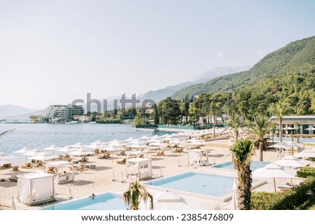 Luxurious sandy beach with sun loungers and white parasols at the One and Only Hotel. Portonovi, Montenegro