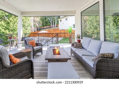 A Luxurious Spacious Deck With Stylish Patio Furniture With A Fire Pit Table Heater