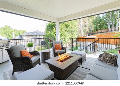 A Luxurious Spacious Deck With Stylish Patio Furniture With A Fire Pit Table Heater